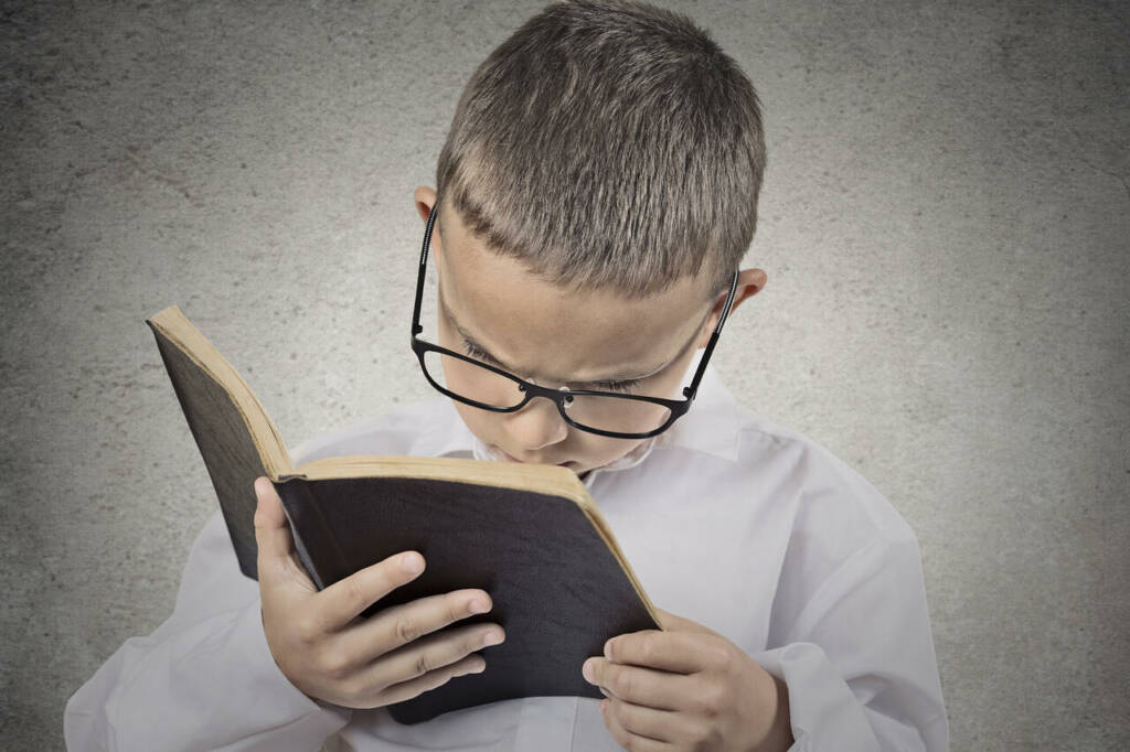 Close,Up,Portrait,Young,,Little,Man,With,Glasses,Holding,,Reading